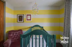 striped nursery with white and yellow walls