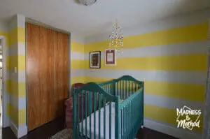 yellow and white stripe walls with green crib