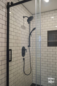 white subway tile black fixtures in shower