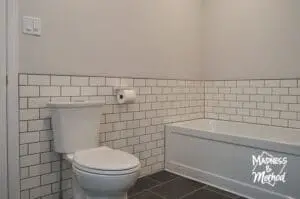 white subway tile behind toilet and tub
