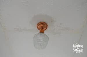 drywall mud around light fixture on damaged ceiling