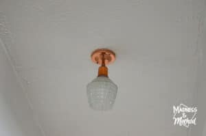 copper light fixture on white textured ceiling