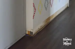 baseboards missing on white walls with dark vinyl floors