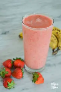 pink smoothie in clear glass with fruit