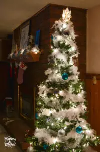 christmas tree in basement next to brick fireplace
