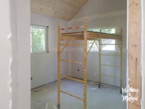 cottage bedroom with scaffolding and planked ceiling