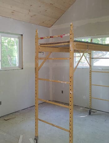 cottage bedroom with scaffolding and planked ceiling