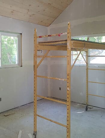 cottage bedroom with scaffolding and planked ceiling