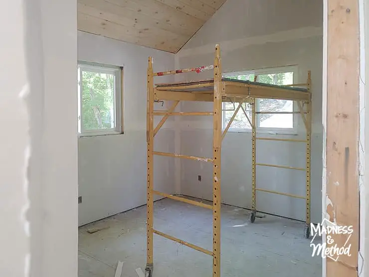 cottage bedroom with scaffolding and planked ceiling