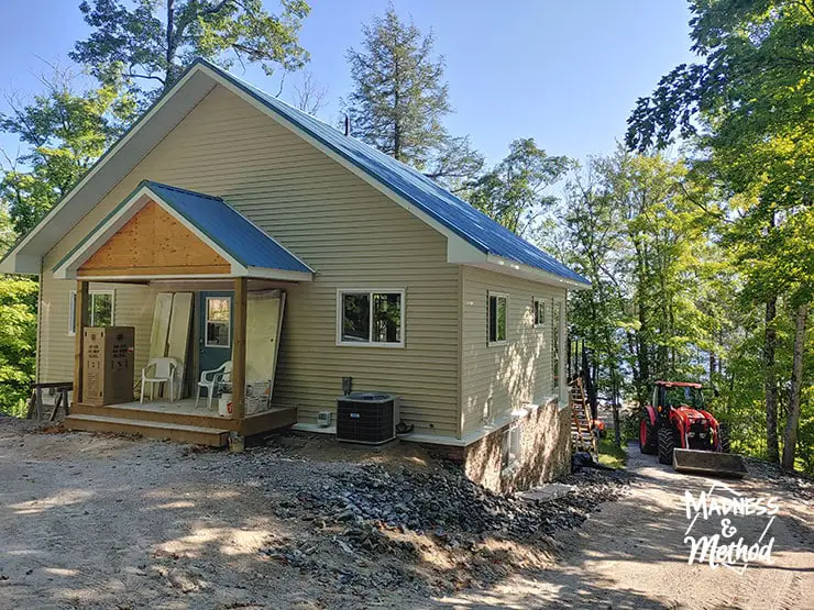 beige cottage with blue slate metal roof