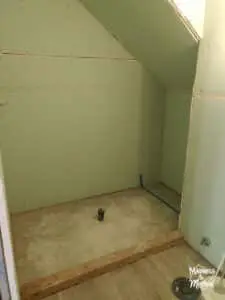 angled shower under stairs