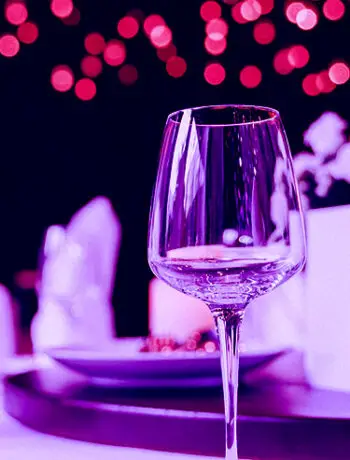 wine glass on table with purple background