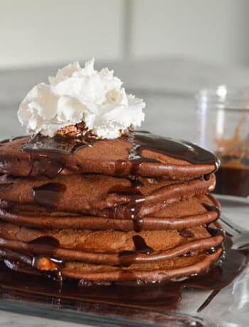 triple chocolate pancakes with syrup and whipped cream