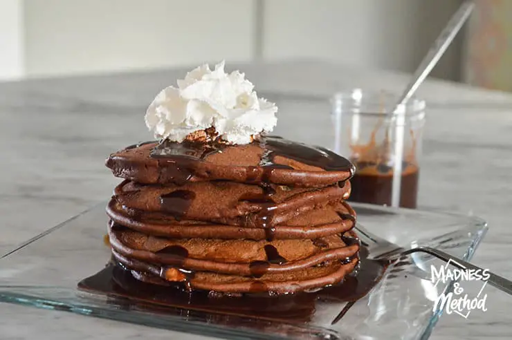 triple chocolate pancakes with syrup and whipped cream