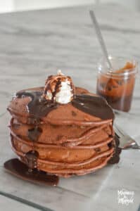 triple chocolate pancakes with syrup and whipped cream