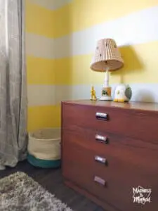 yellow white striped walls brown dresser