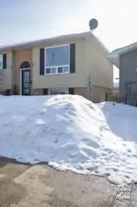 snow pile in front of raised ranch house