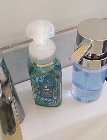 soap bottles on sink next to faucet