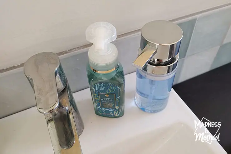soap bottles on sink next to faucet
