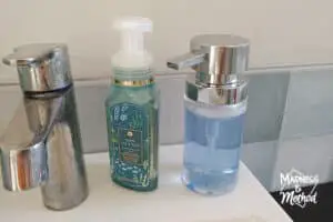 dirty chrome faucet next to soap bottles