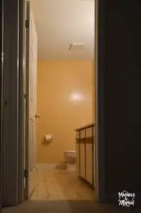 dark hallway looking at beige bathroom