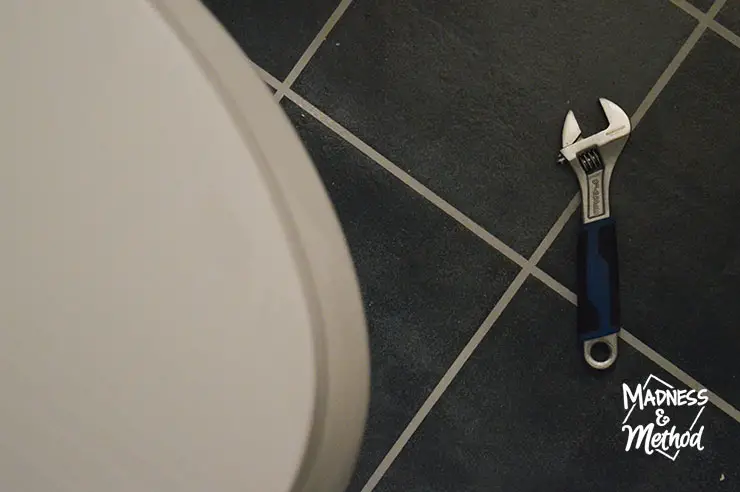 wrench on ground near toilet