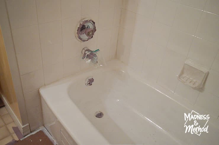 white painted bathtub and tiles