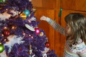 girl helping decorate tree