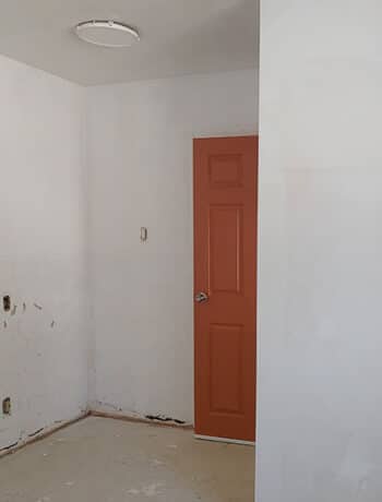 primed empty room orange door