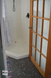 white bathroom shower with black floors