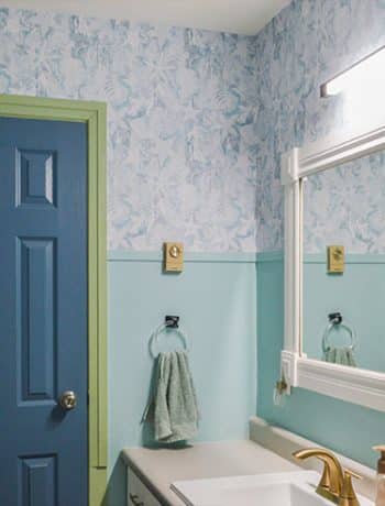 bathroom with light teal walls and dark blue door