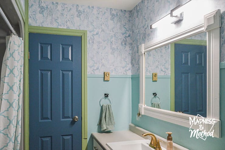 bathroom with light teal walls and dark blue door