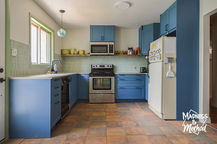 blue kitchen cabinets with terra cotta floors