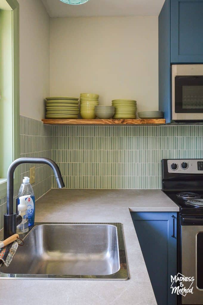 green backsplash with open shelf